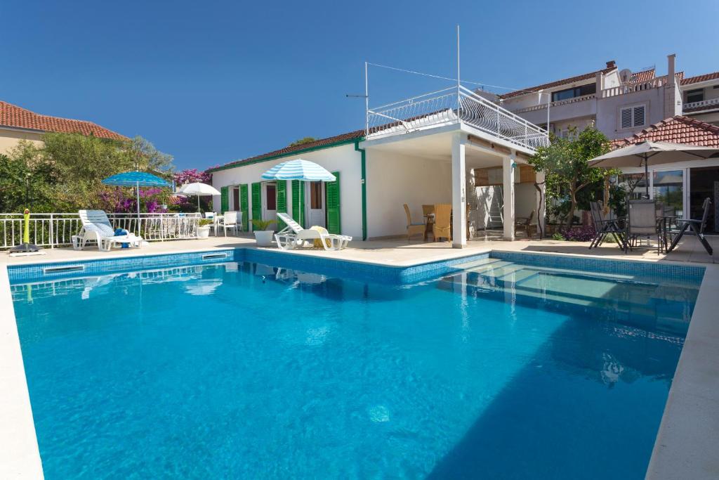 una gran piscina azul frente a una casa en Aras Wind Rose, en Supetar