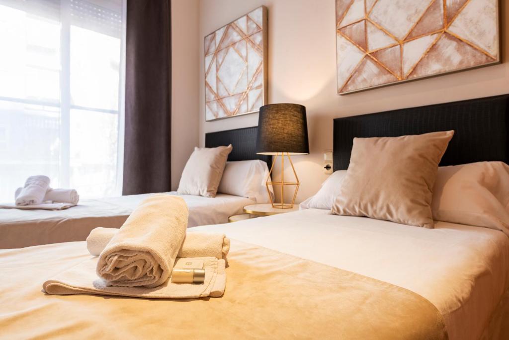 um quarto com 2 camas e toalhas em Abastos Apartment Center em Valência