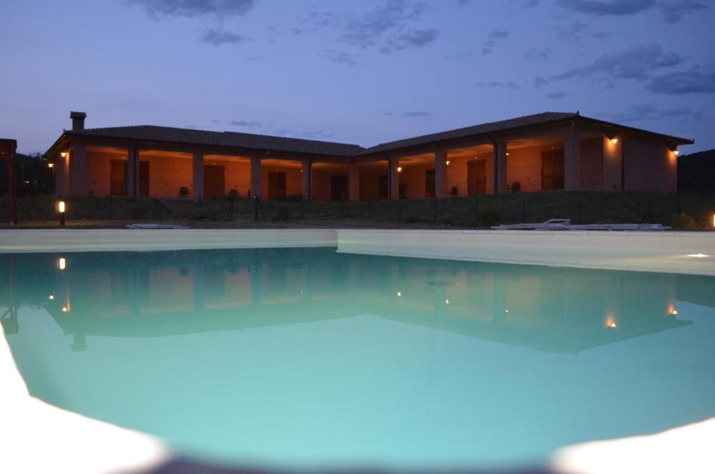ein Haus mit Pool in der Nacht in der Unterkunft Residence Le Casine in Batignano