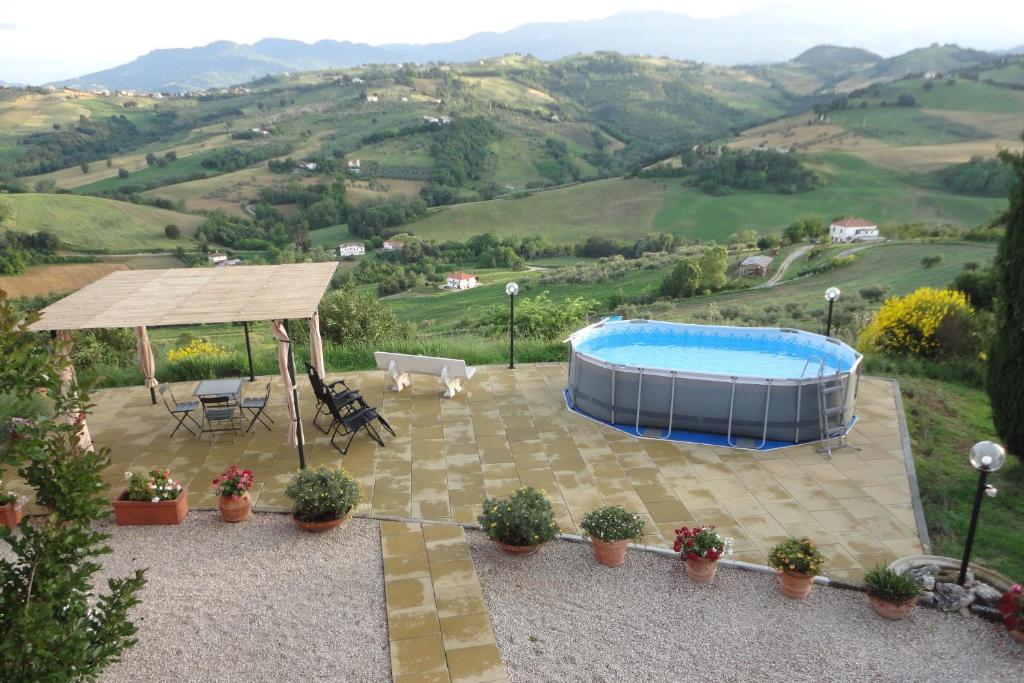 un patio con piscina, mesa y sillas en Casa Adriana, en Penne