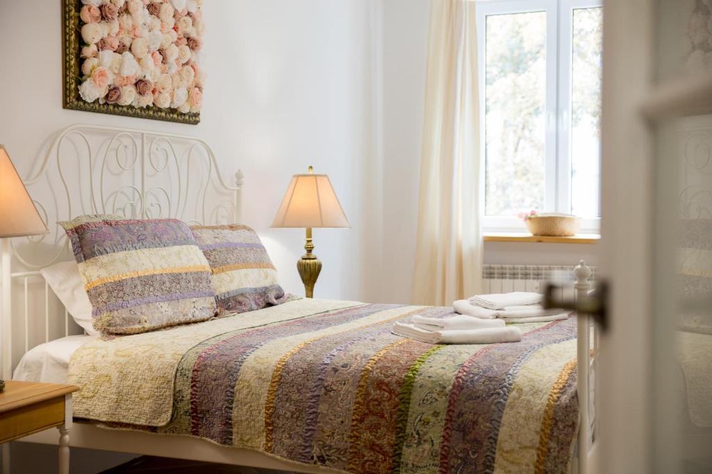 ein Schlafzimmer mit einem Bett mit einer Decke und einem Fenster in der Unterkunft Royal Route Apartment for 10 people in Warschau