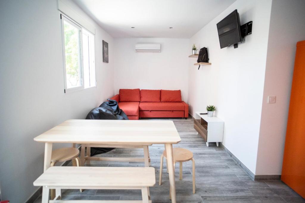 a living room with a red couch and a table at PISO DE DISEÑO A 5 MIN ANDANDO DE LA PLAYA in Valencia