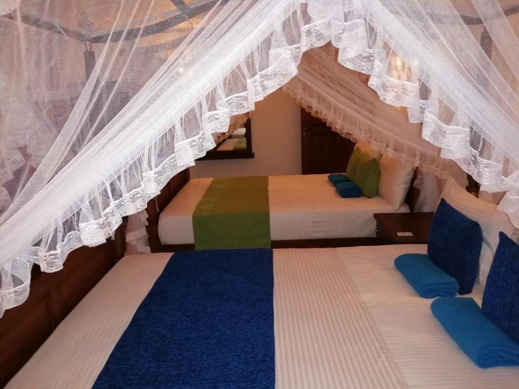 2 letti in una camera con baldacchino di Suriya Homestay Mirissa a Mirissa
