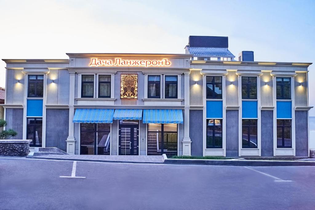 um hotel com um parque de estacionamento em frente em Boutique Hotel Dacha Lanzheron em Odessa