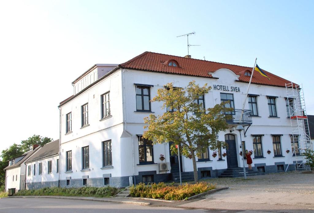 Un edificio bianco seduto sul lato di una strada di Svea hotell, Vollsjö a Vollsjö