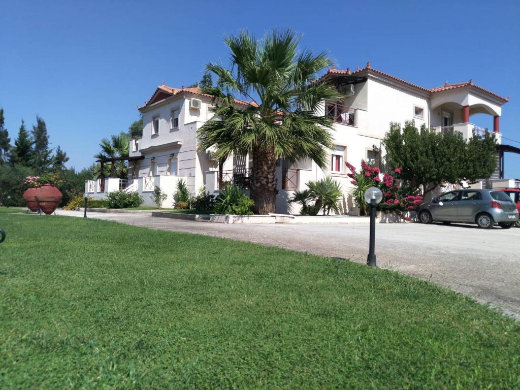 a white house with a palm tree and a parking meter at ilyda Residence apts in Skala Kallonis