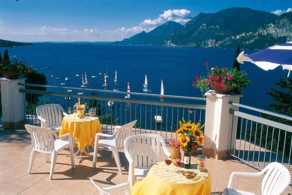 stół i krzesła na balkonie z widokiem na wodę w obiekcie Hotel Villa Orizzonte w mieście Malcesine