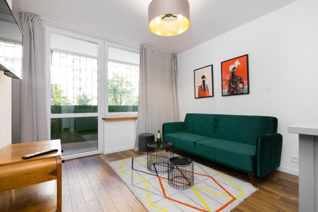 un soggiorno con divano verde e tavolo di Independence Museum Charming Apartment a Varsavia