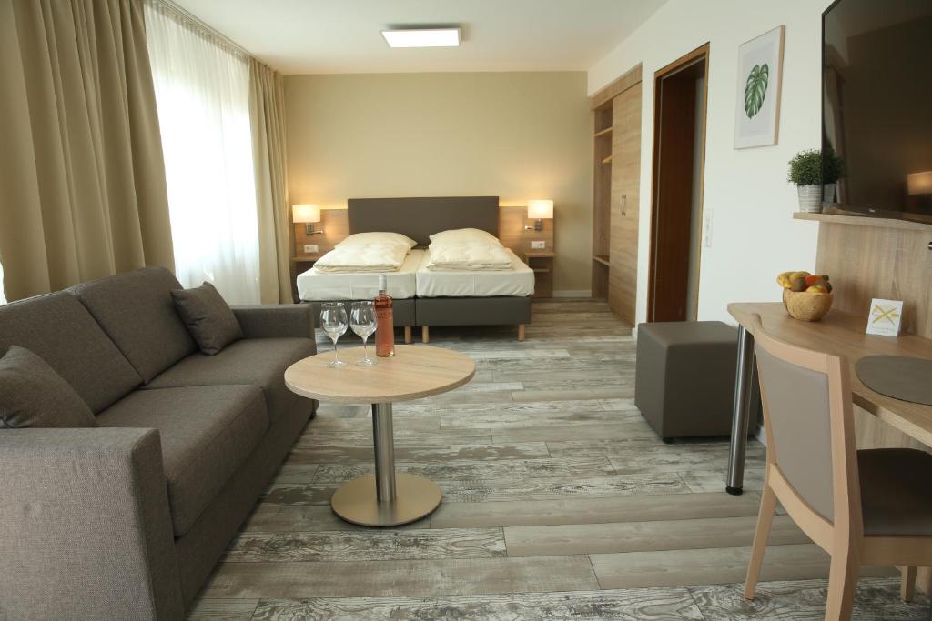 - un salon avec un canapé et un lit dans l'établissement Kemnater Hof Apartments, à Ostfildern
