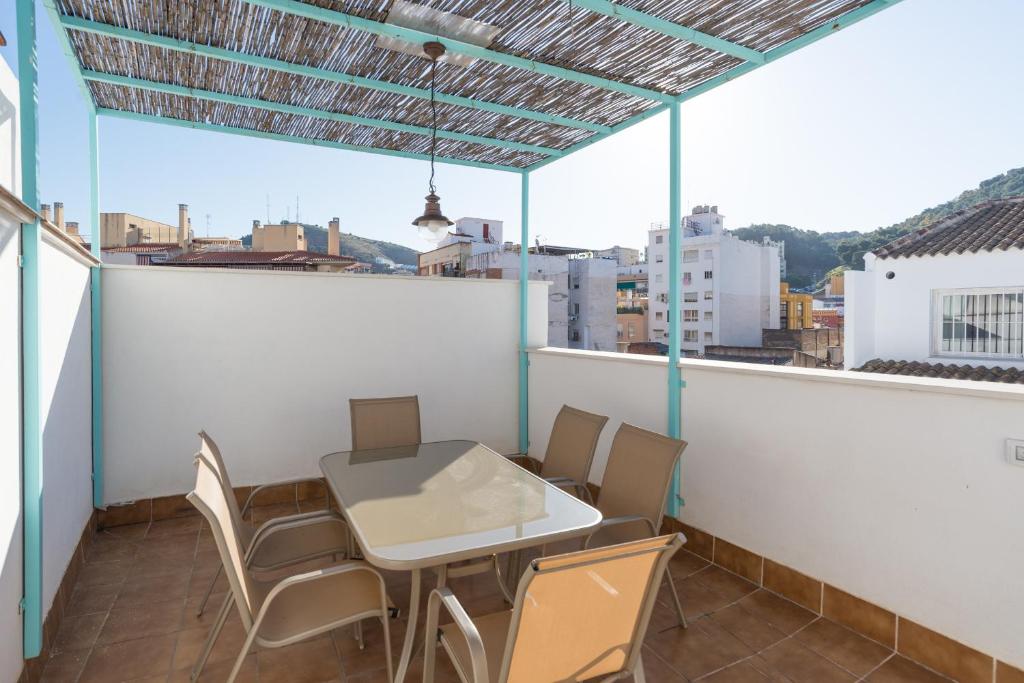 balcón con mesa y sillas en el techo en LU&CIA TERRAZA LAGUNILLAS, en Málaga