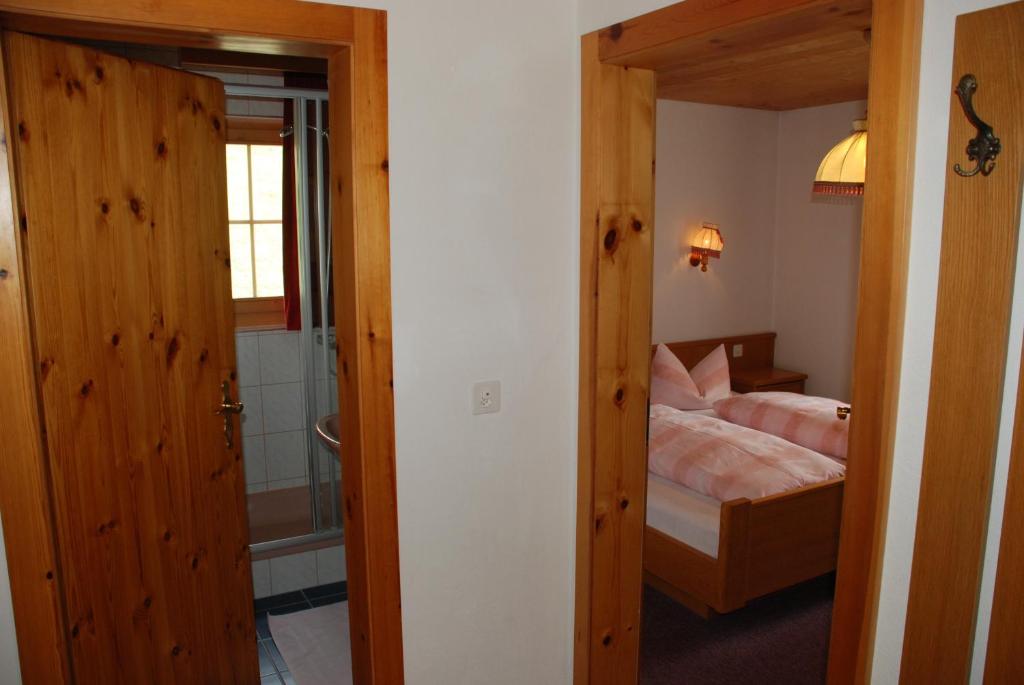 a bedroom with a bed and a door leading to a bathroom at Appartment & Taxi Tirana in Samnaun