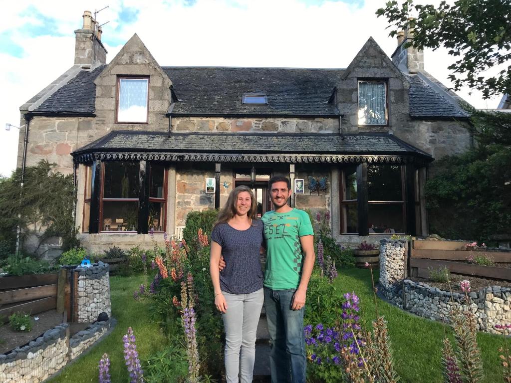 a man and a woman standing in front of a house at Garden Park Guest House in Grantown on Spey