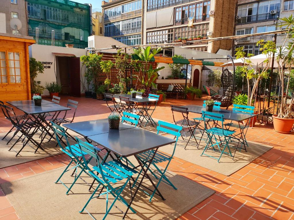 a patio area with tables, chairs, and tables with umbrellas at Rodamon Barcelona Hostel in Barcelona