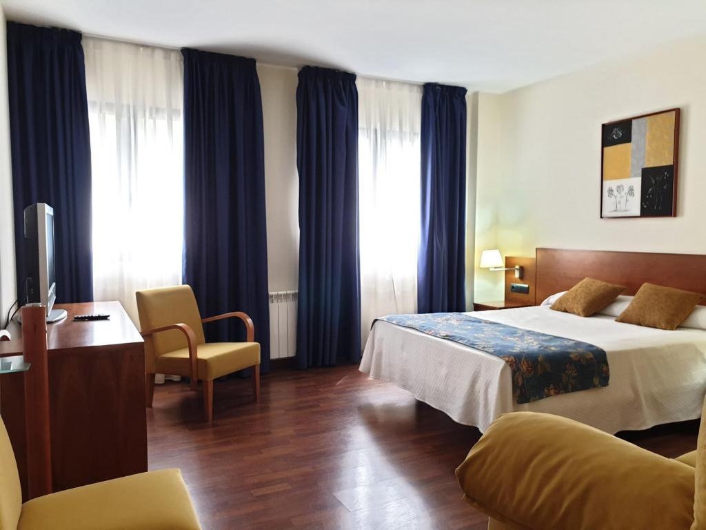 Habitación de hotel con cama y escritorio en Hotel Suite Camarena, en Teruel