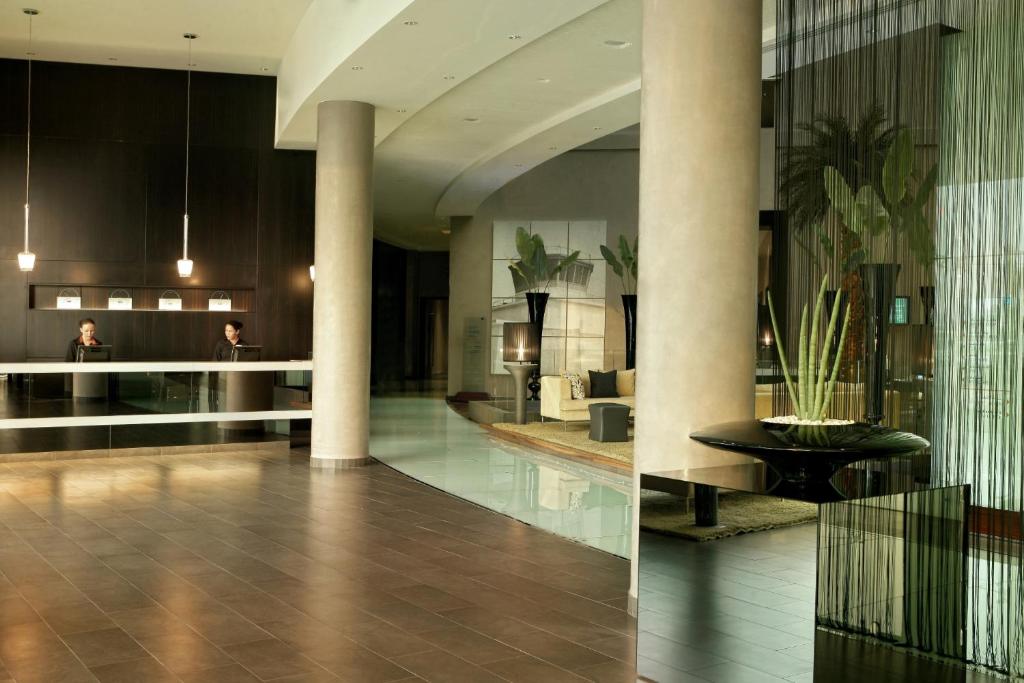 a lobby of a hotel with columns and a table at Centro Sharjah in Sharjah