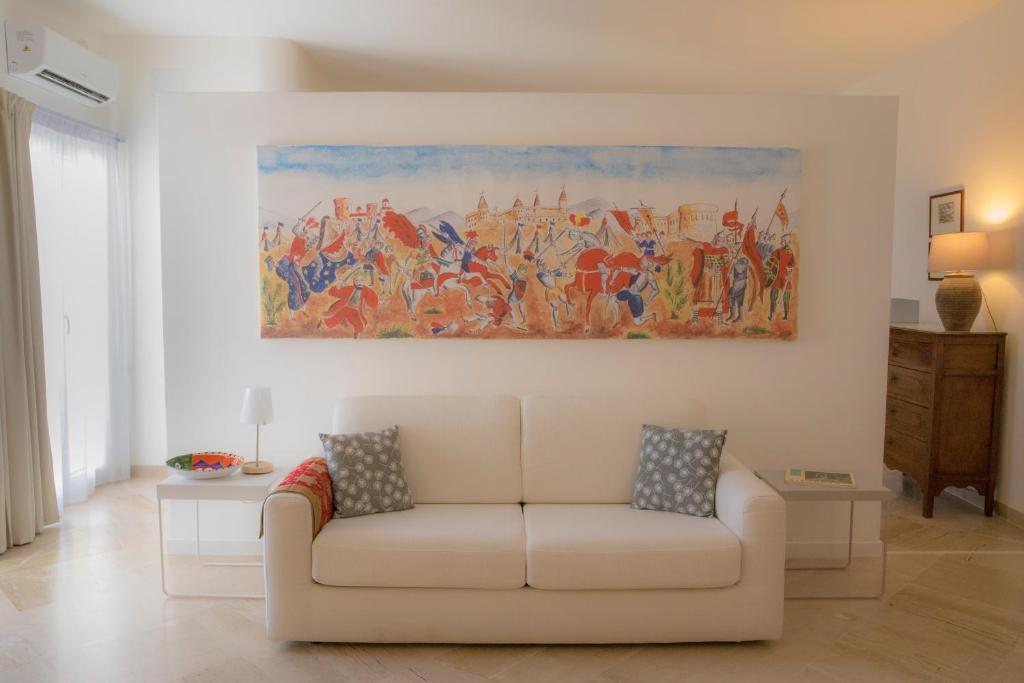 una sala de estar con sofá y una pintura en la pared en Residenza Lago, en Siracusa