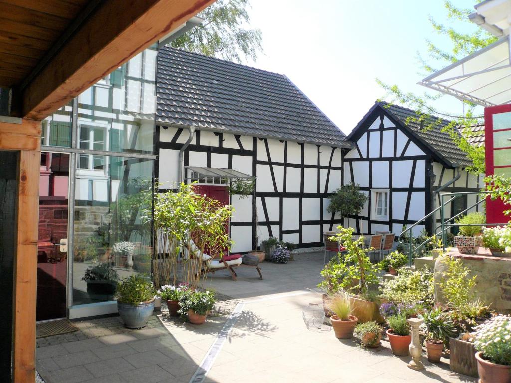 a house with a courtyard with potted plants at Ferienhaus im Fachwerkhof 'Haus in Bewegung' in Seelscheid