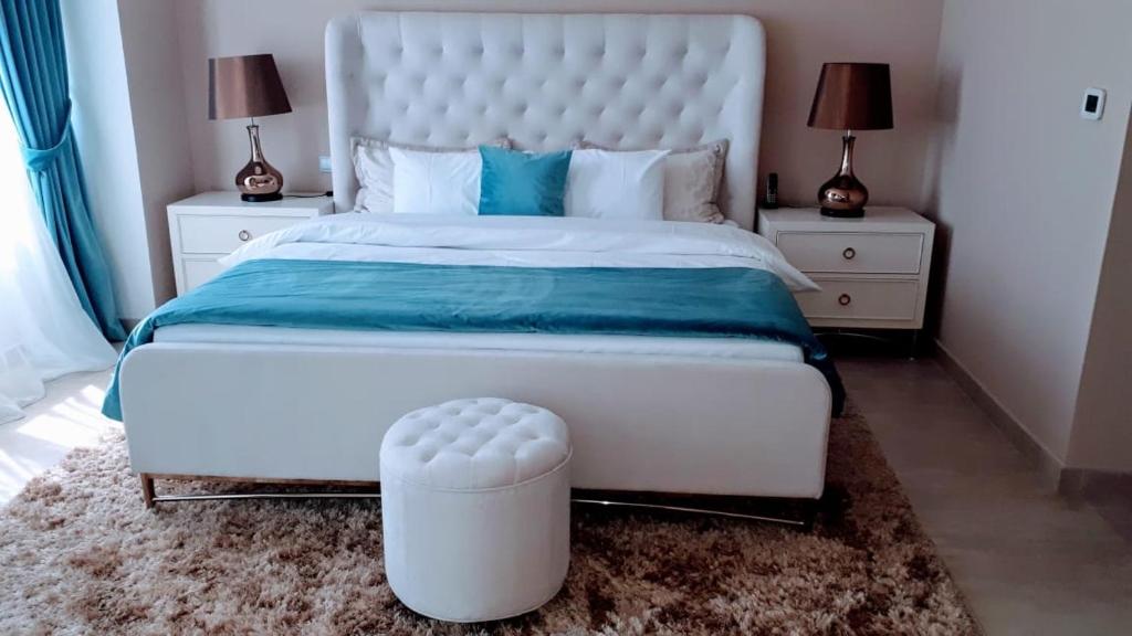 um quarto com uma grande cama branca e duas mesas de cabeceira em JCB Dubai Marina Apartment em Dubai