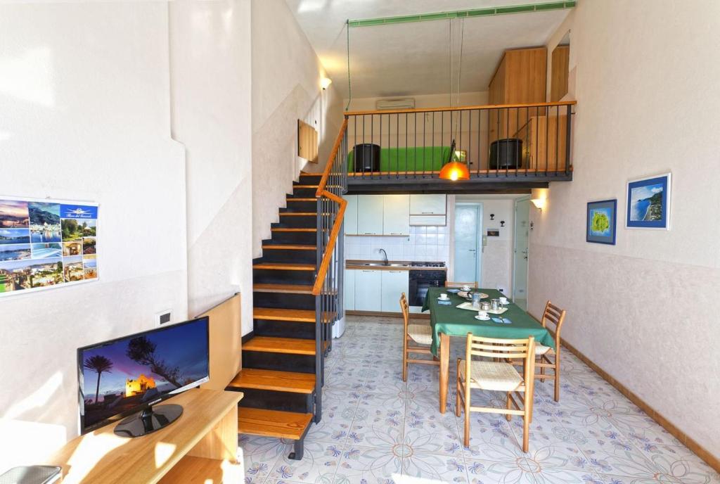 a living room with a dining room table and a staircase at Casa Vacanze Parco Del Generale in Ischia