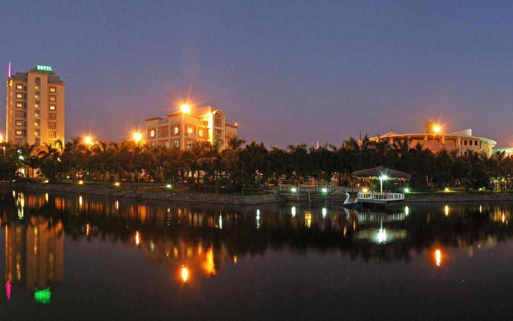 a city with buildings and a river at night at Camela Hotel & Resort in Hai Phong