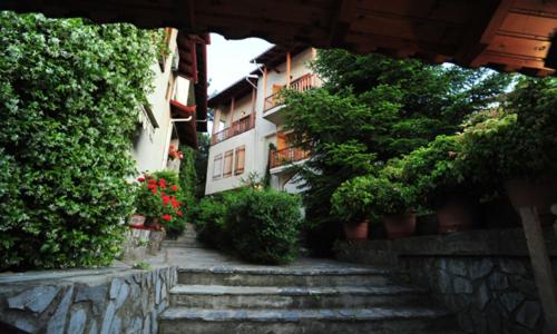 un groupe de bâtiments avec des escaliers et des plantes dans l'établissement Guesthouse Papanikolaou, à Litochoro