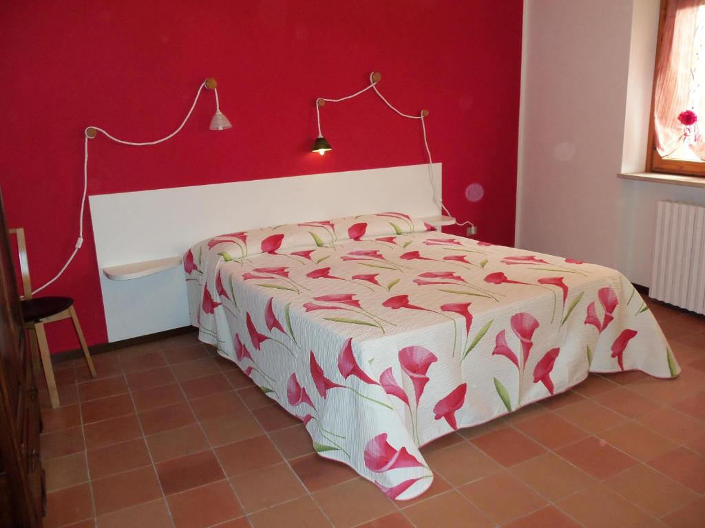 a bedroom with a bed with a red wall at Appartamento San Bastian in CastellʼAlfero