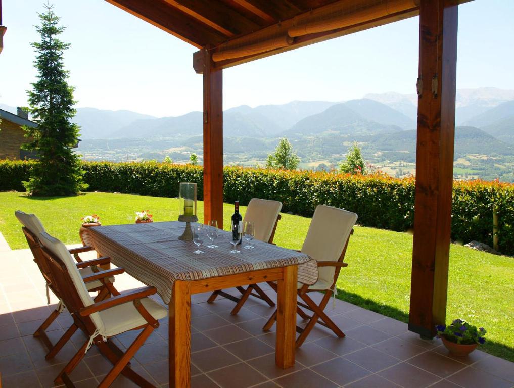 una mesa de madera y sillas en un patio en Casa para familias en Prullans, en Prullans