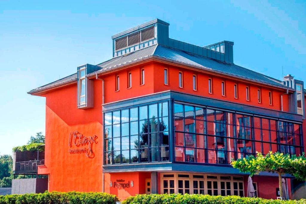 ein rotes Gebäude mit vielen Fenstern in der Unterkunft Hotel Simon's Plaza in Grevenmacher