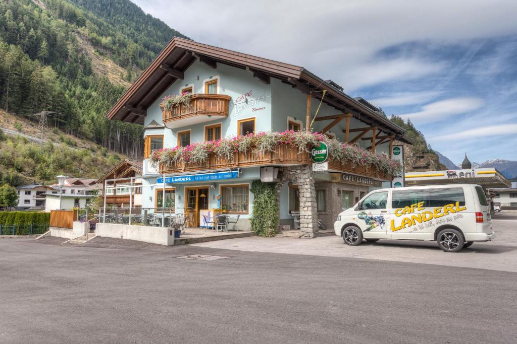 una furgoneta blanca estacionada frente a un edificio en Café Landerl, en Matrei in Osttirol