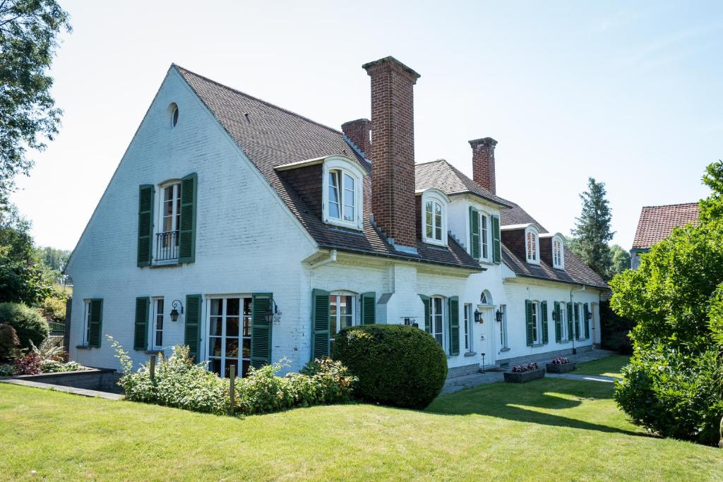 a large white house with green shutters at B&B El Tyu in Écaussinnes-dʼEnghien