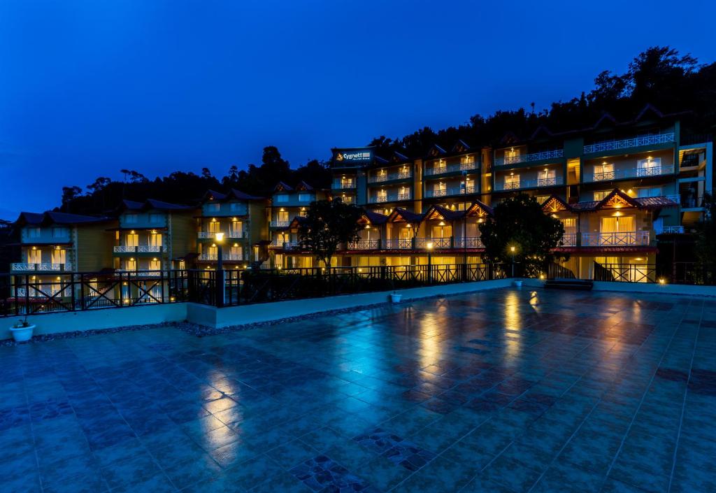 奈尼塔尔Cygnett Resort Mountain Breeze的夜间酒店,前方设有游泳池