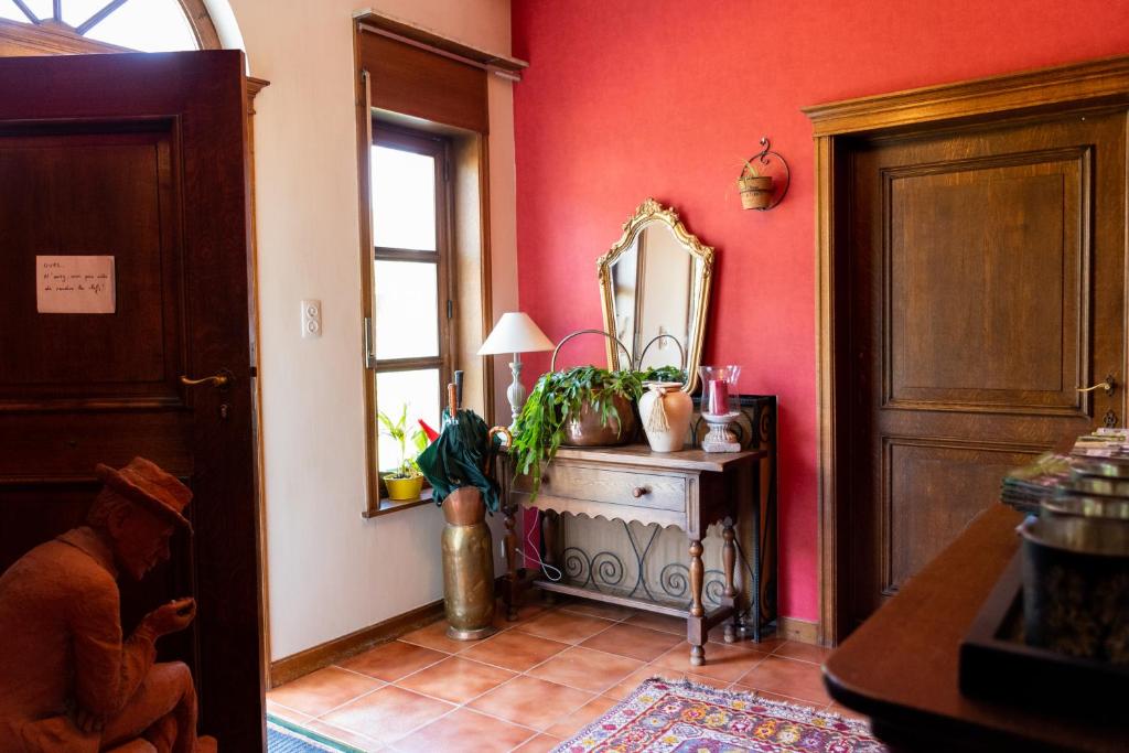 a room with a mirror and a table with a plant at B&B El Tyu in Écaussinnes-dʼEnghien