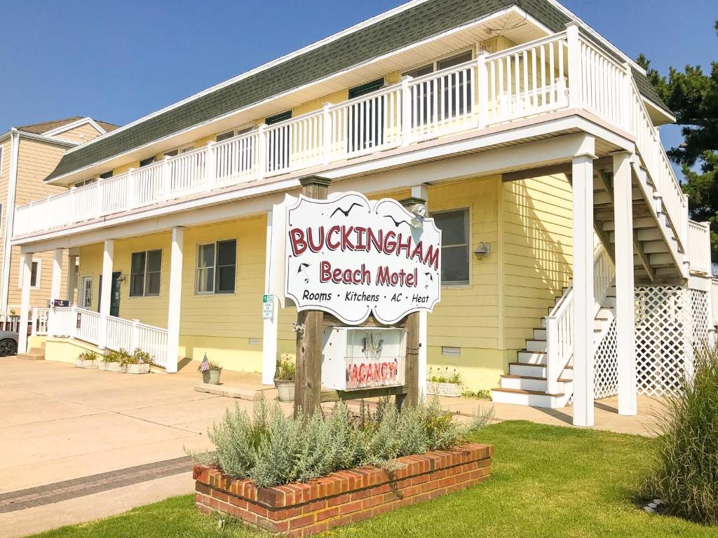 um edifício amarelo com uma placa para um motel de praia em The Buckingham Motel em Cape May