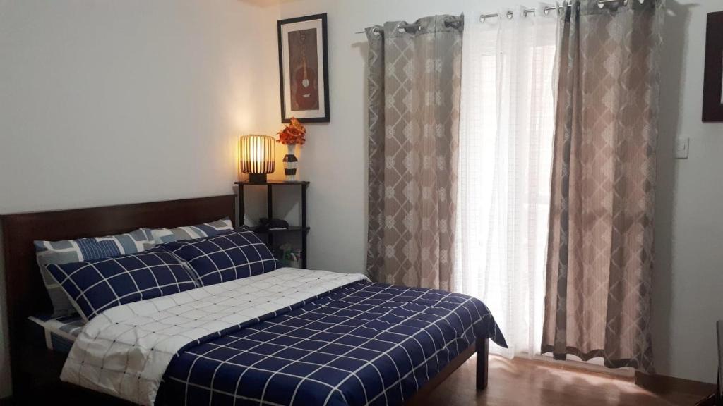 a bedroom with a bed and a window with curtains at Comfy condo unit 5mins from Mactan Airport+Netflix in Mactan