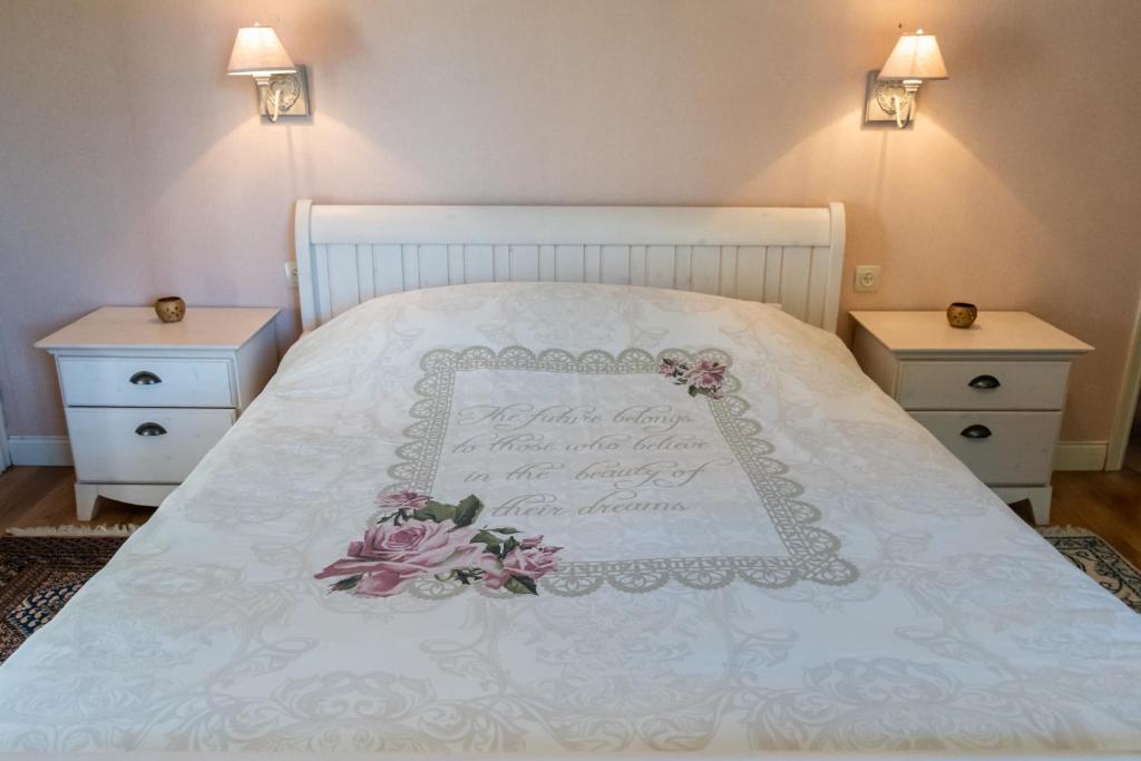 a bedroom with a white bed with a sign on it at B&B El Tyu in Écaussinnes-dʼEnghien