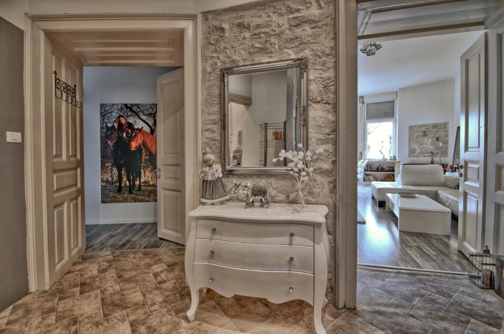 ein Bad mit einem Waschbecken und einem Spiegel in der Unterkunft Luxury with sea view in Pula