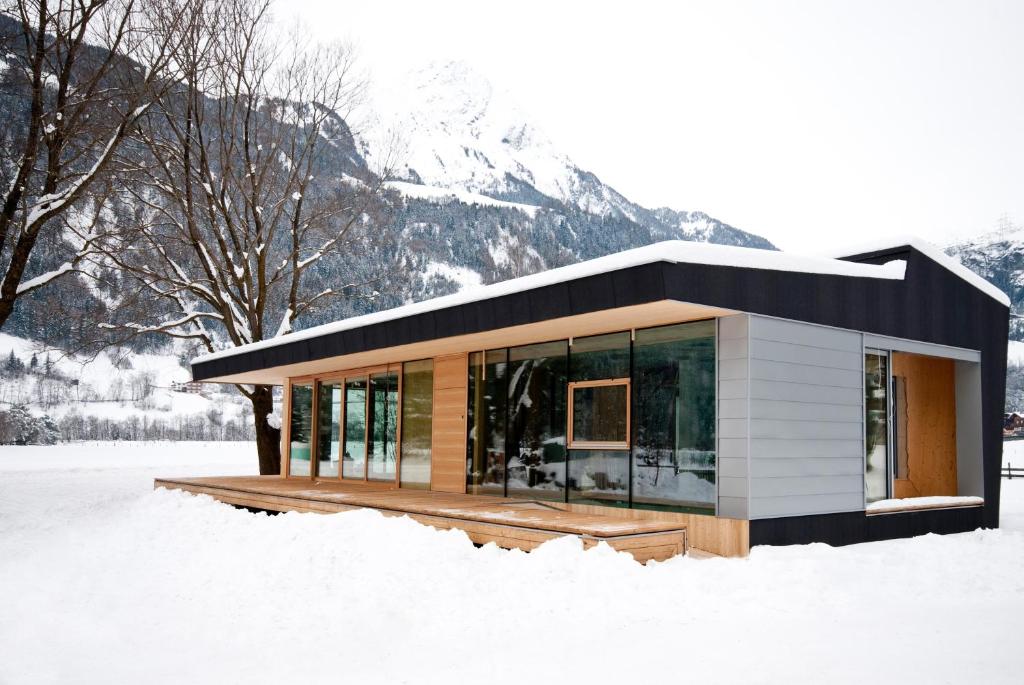 a small house in the snow in front of a mountain at Designhaus COOP in Matrei in Osttirol
