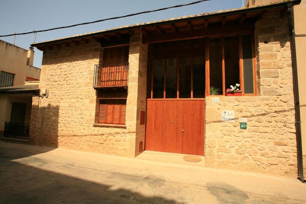 een bakstenen gebouw met een houten deur en een raam bij La Premsa in Arnés