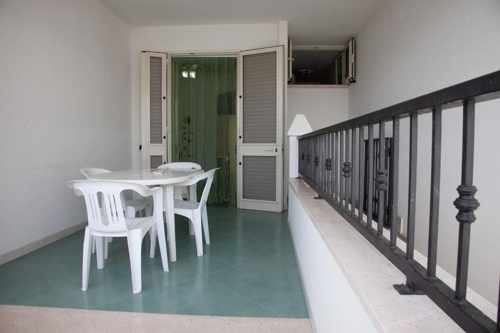 balcone con tavolo e sedie. di Appartamento Mozart 2 a Pescoluse a Marina di Pescoluse