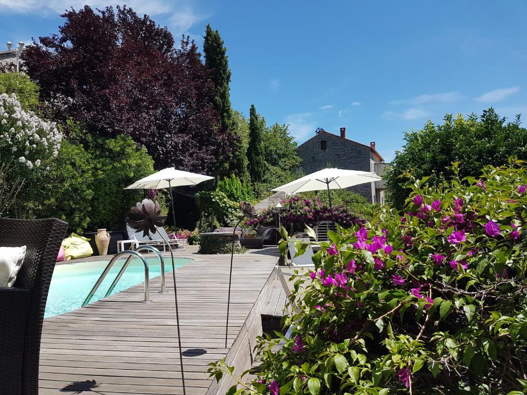 una terraza de madera con sombrillas y una piscina en la VILLA GUIDI en Pila-Canale