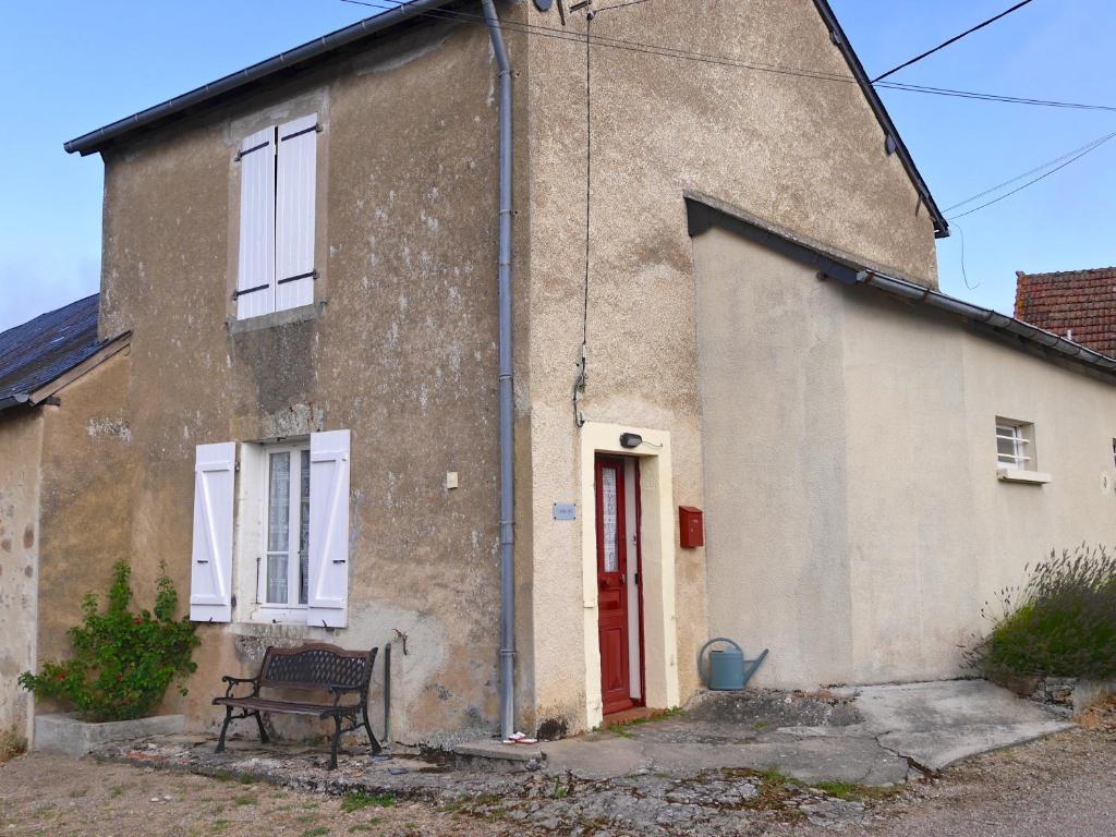 una casa de ladrillo con un banco delante de ella en vakantiehuis Morvan en Dun-sur-Grandry