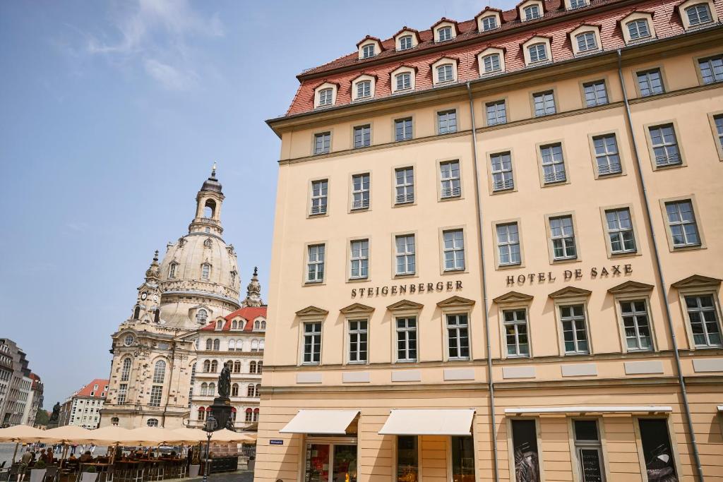 ein Gebäude in einer Stadt mit einem Uhrturm in der Unterkunft Steigenberger Hotel de Saxe in Dresden