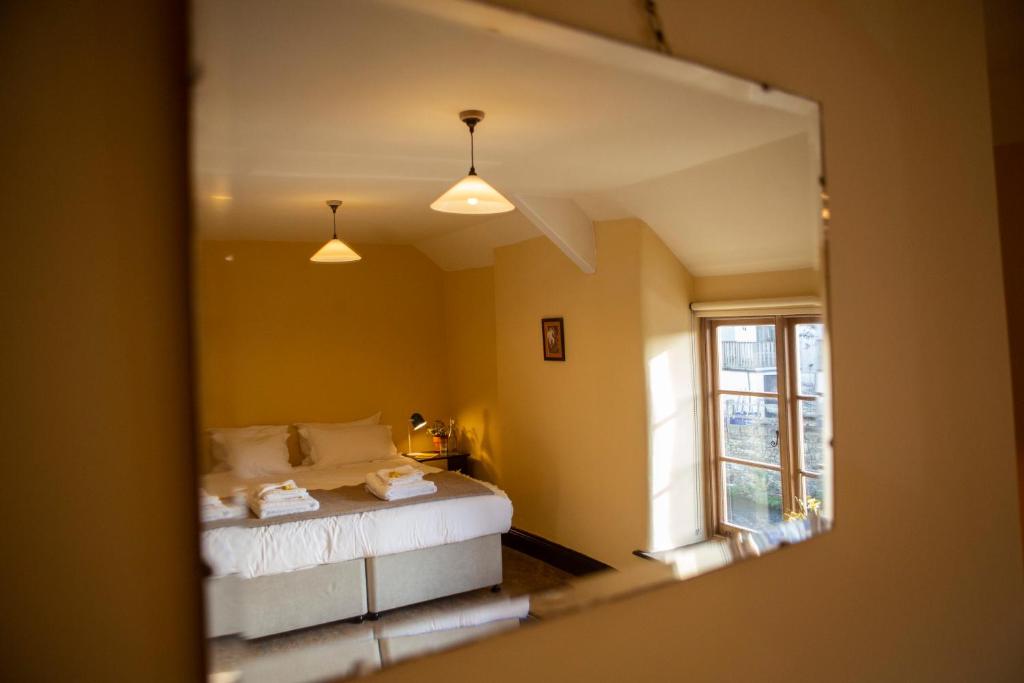 Schlafzimmer mit einem Bett und einem Spiegel in der Unterkunft The Leaping Salmon in Yelverton