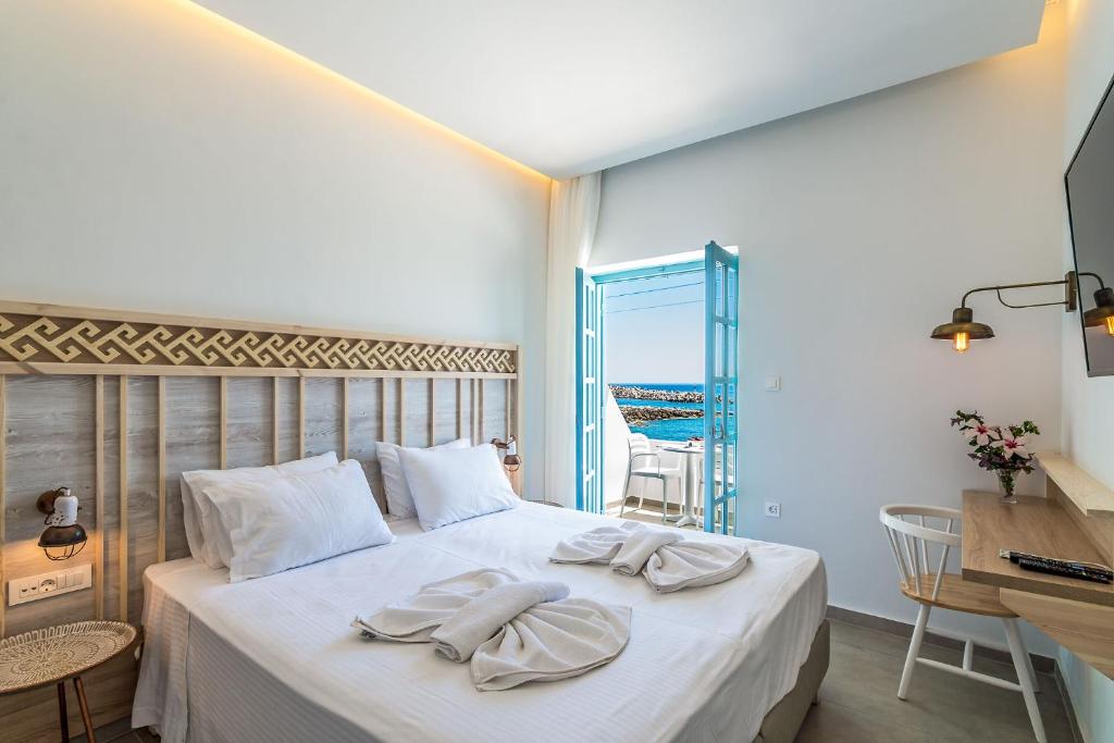 a bedroom with a bed with towels on it at Livikon by the Sea in Hora Sfakion