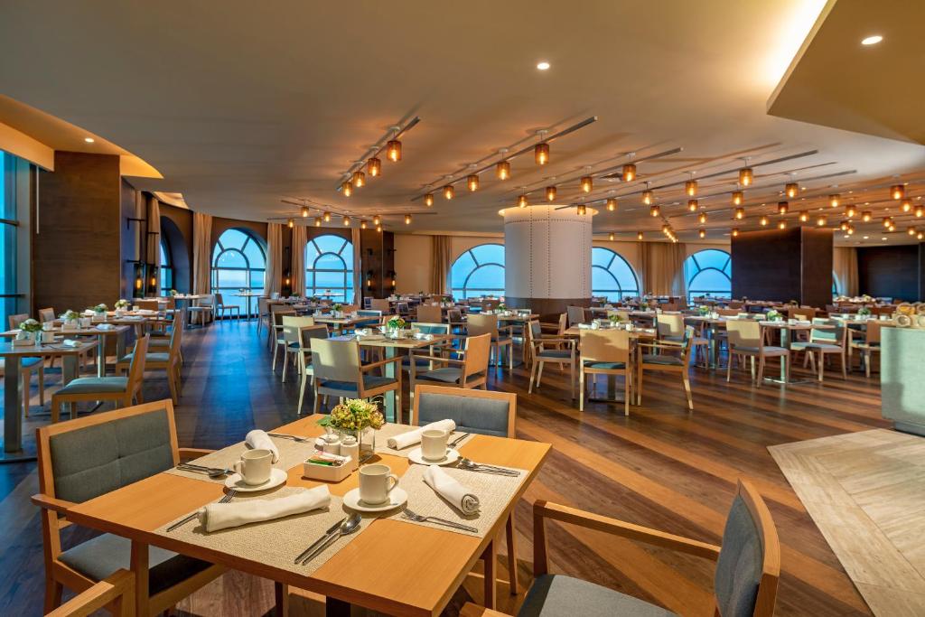 a dining room with wooden tables and chairs at Catalonia Santo Domingo in Santo Domingo