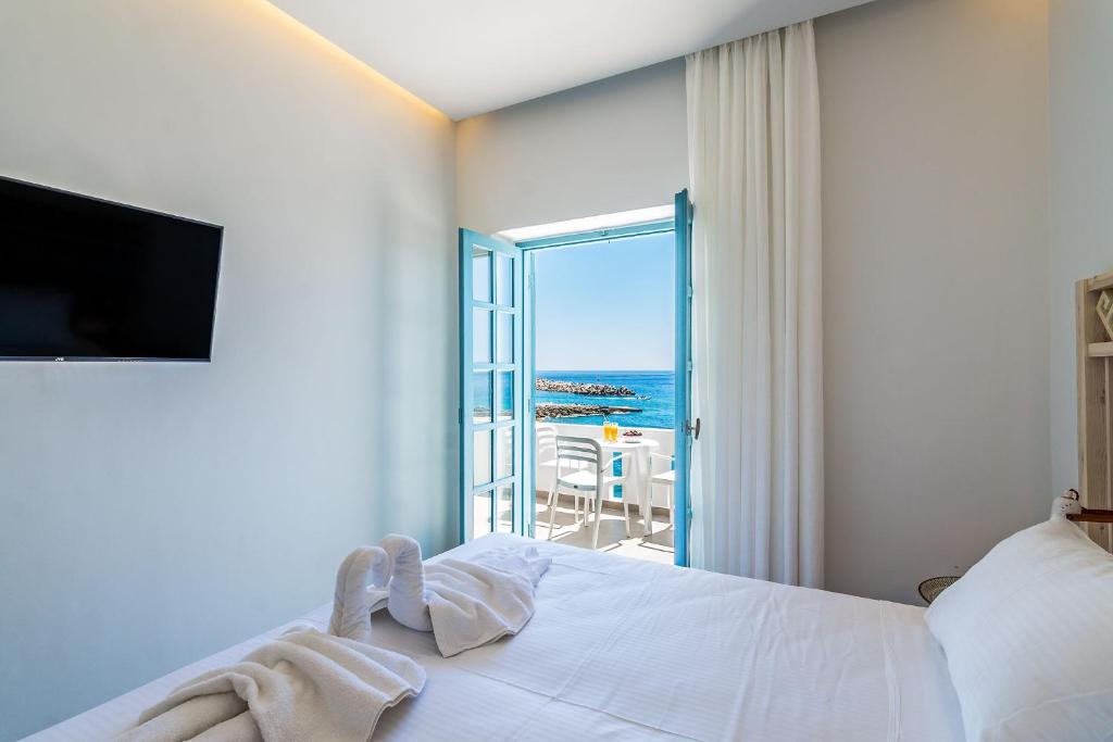 a bedroom with a bed and a view of the ocean at Livikon by the Sea in Hora Sfakion
