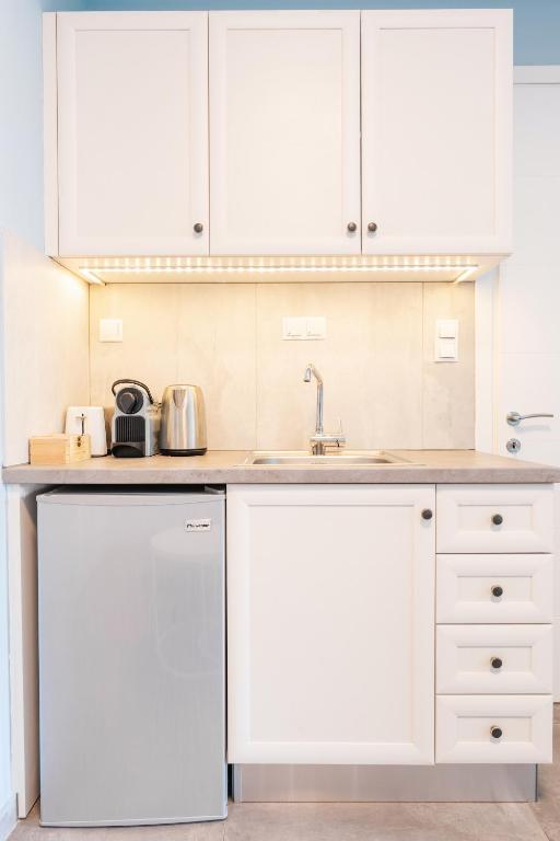 kuchnia z białymi szafkami i zlewem w obiekcie Modern White Tower Apartment w Salonikach