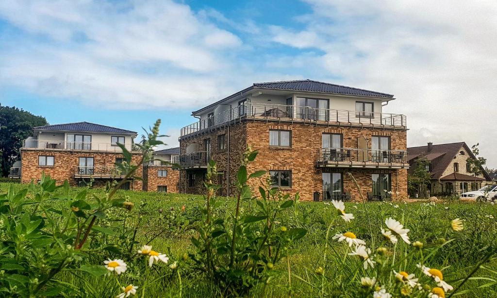 un gran edificio de ladrillo en un campo de flores en Appartements an der Golfanlage, en Warnemünde