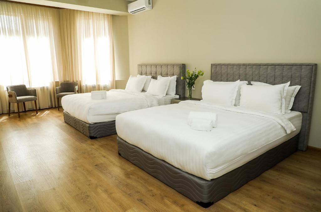 um quarto de hotel com duas camas com almofadas brancas em Teryan Pushkin Apart Hotel em Yerevan