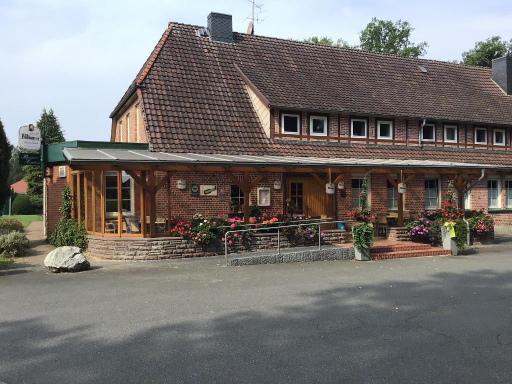 un pequeño edificio con flores delante en Brammers Landhotel Zum Wietzetal, en Wietzendorf